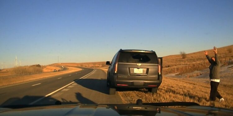 Kansas trooper rescuing a kidnapped 6-year-old girl and taking two men into custody during a traffic stop on a road