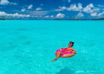 Woman relaxing on an inflatable donut float in a turquoise ocean at a Caribbean resort