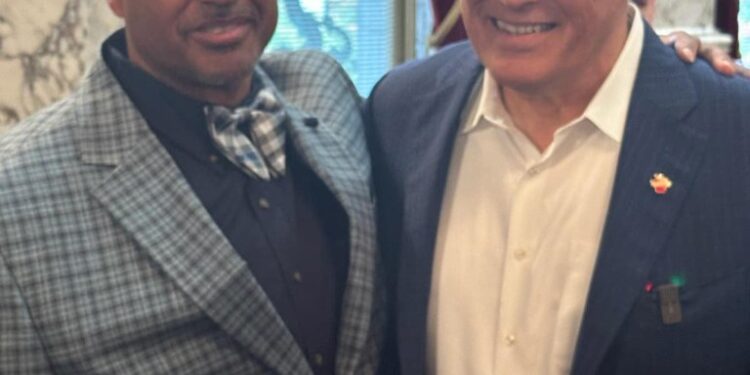 Two men, including celebrity Jay Inslee, standing together and smiling on Percy Levy's Facebook page