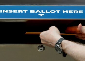A person inserting a sample ballot into a New York State Secure Ballot Dropbox during a legislative rally in New York City, August 2020