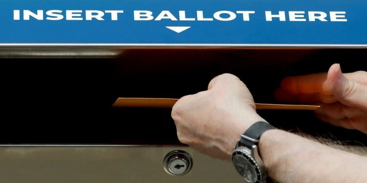 A person inserting a sample ballot into a New York State Secure Ballot Dropbox during a legislative rally in New York City, August 2020