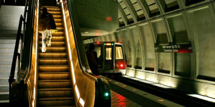 Metro rider climbs the escalator after exiting the train in the Mt. Vernon Square station where a train derailed Sunday in Washington on Monday, Jan. 8, 2007.
