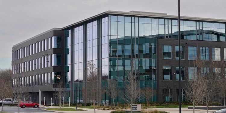 A photo shows a gray and blue building in the center.