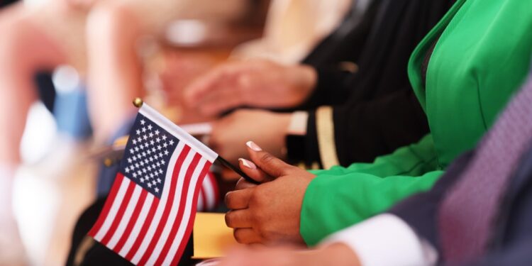 Person holding an American flag at a naturalization ceremony.