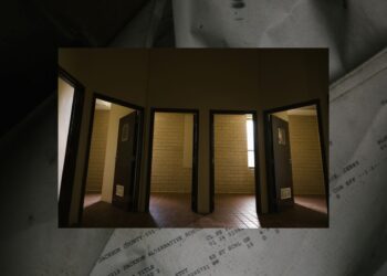 A photo shows five open doors right next to each other, with a yellowish wall in the rooms. One room has part of a window visible. This photo is overlaid on a photo showing a partially folded and crumpled piece of paper with the words "Jackson County", "Jackson Alternative School" and "Title: Read 2" typed on it.