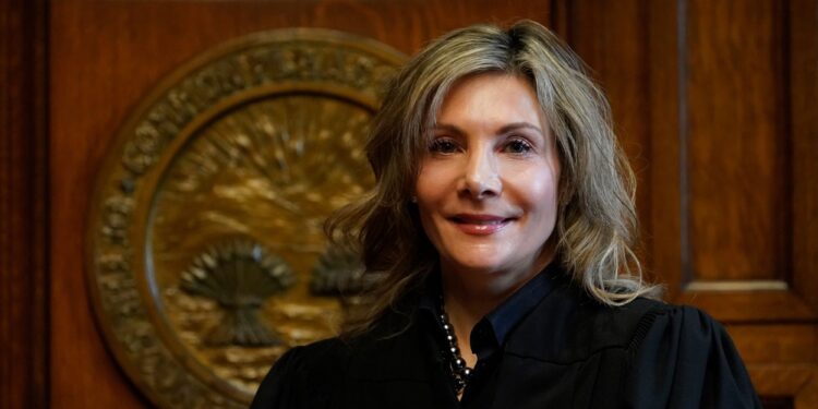 Celebrezze, a White woman with dark blonde hair, wears a black judge's robe.