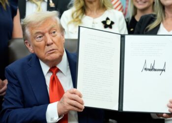 President Trump holding a signed proclamation.