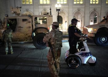 National Guard and police officers patrolling Washington, D.C. at night.