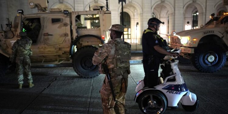 National Guard and police officers patrolling Washington, D.C. at night.