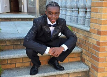 Sanjay Samuel 13 sitting on brick stairs in a suit and bow tie.