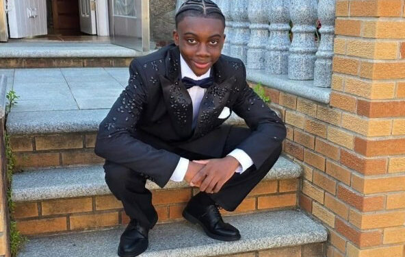 Sanjay Samuel 13 sitting on brick stairs in a suit and bow tie.