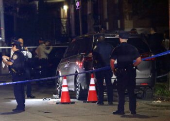 Police investigate a possible homicide scene in Queens, with blue police tape and orange cones visible.