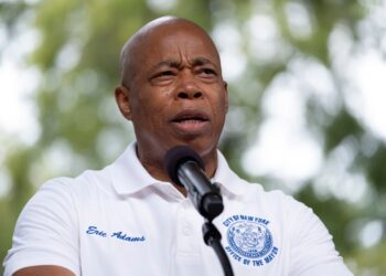 Mayor Eric Adams speaking at a microphone.