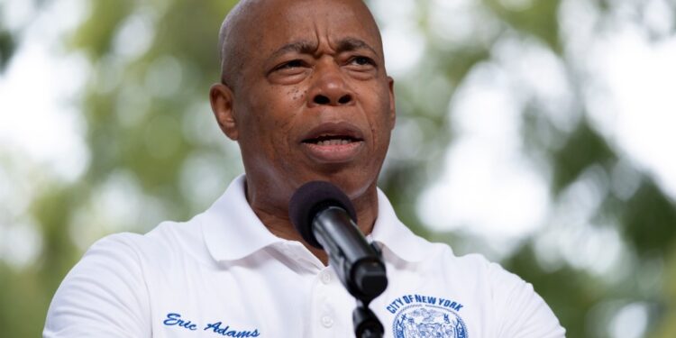 Mayor Eric Adams speaking at a microphone.