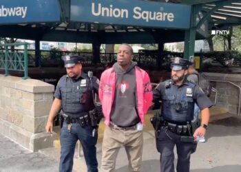 Aaron Walker escorted out of the Union Square subway station by two police officers.