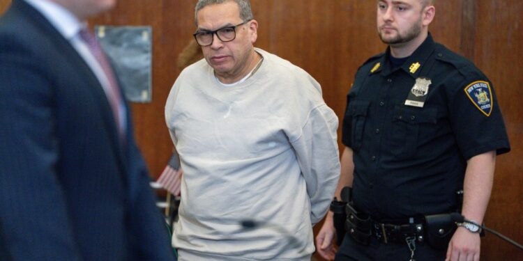 espinoza in grey sweatshirt and khakis with his arms behind him during a court appearance