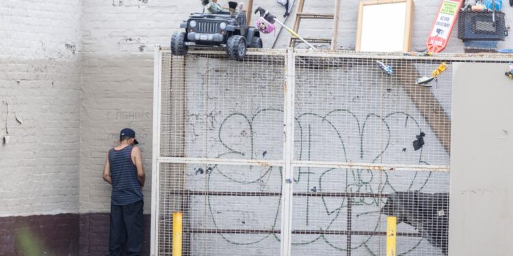 A man pees outside a Rite Aid in Astoria.
