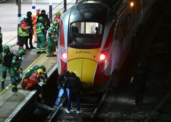 Police and emergency workers search the track beneath an LNER Azuma train at Huntingdon Station in Huntingdon, England after a stabbing attack on Nov. 1, 2025.