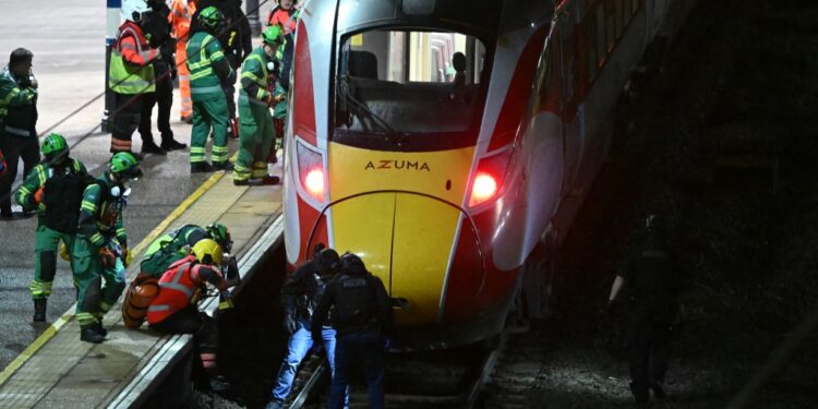 Police and emergency workers search the track beneath an LNER Azuma train at Huntingdon Station in Huntingdon, England after a stabbing attack on Nov. 1, 2025.