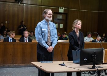Charles Foehner standing in court next to a woman in a black suit.
